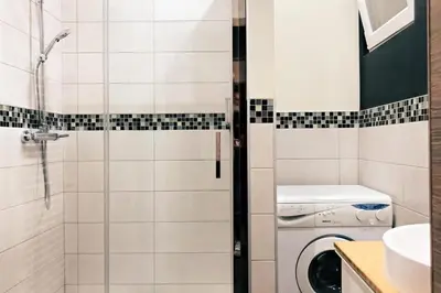 a bathroom with a shower and a washing machine at Renovated one bedroom apartment Schuman area in Brussels