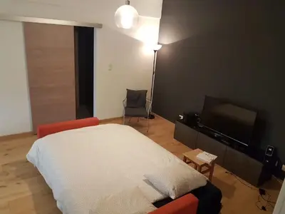 a bedroom with a bed and a flat screen tv at Renovated one bedroom apartment Schuman area in Brussels