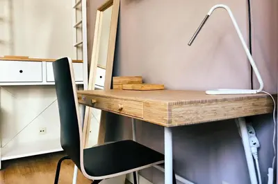 a desk with a chair next to a desk with a computer at Charming little studio in Brussels