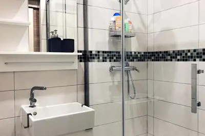a bathroom with a sink and a shower at Charming little studio in Brussels