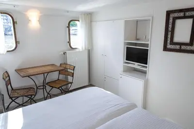 a small bedroom with a bed and a table and chairs at Hotel The Boatel in Ghent