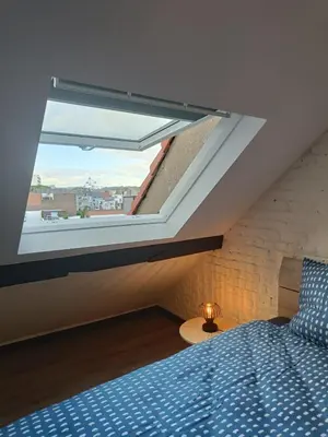 a bedroom with a bed and a large window at Modern Triplex 140m2 - 4 bedrooms, 1 living room & 2 bathrooms - 8 people in Brussels city in Brussels