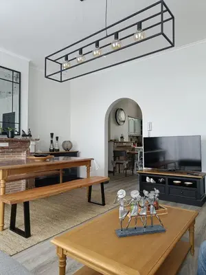 a living room with a table and a tv at Modern Triplex 140m2 - 4 bedrooms, 1 living room & 2 bathrooms - 8 people in Brussels city in Brussels