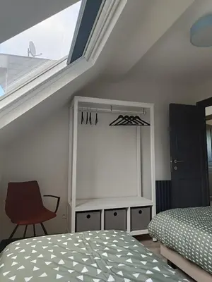 a bedroom with a bed and a window and a chair at Modern Triplex 140m2 - 4 bedrooms, 1 living room & 2 bathrooms - 8 people in Brussels city in Brussels
