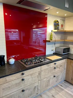 a kitchen with a stove and a red wall at 't Cravael in Meldert