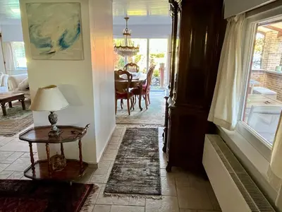 a hallway with a table and a lamp on a table at Vakantiehuis De Bosrand Goor-Asbroek in Hulshout