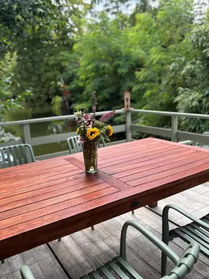 a vase of flowers sitting on a wooden table at CASA LAGO gezellige chalet aan het water in Geel