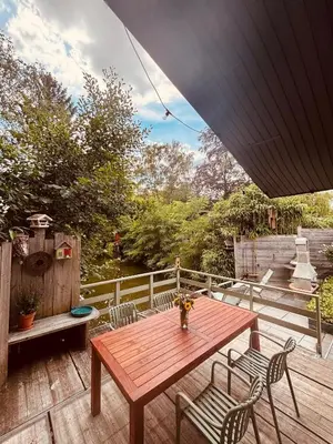 a wooden table and chairs on a wooden deck at CASA LAGO gezellige chalet aan het water in Geel