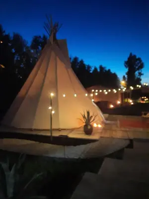 a large white tent with lights on it at night at Tipi Marie met hotutub in de tuin in Kaprijke