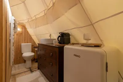 a bathroom with a refrigerator and a toilet in a tent at Tipi Marie met hotutub in de tuin in Kaprijke