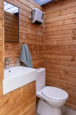 a bathroom with a white sink and a toilet at Tipi Marie met hotutub in de tuin in Kaprijke