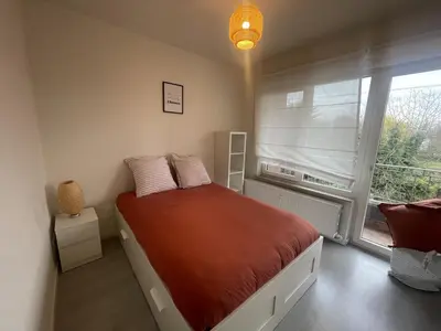a bedroom with a bed in front of a window at Chez HN Confort et Style in Edegem