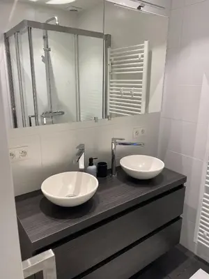 a bathroom with two sinks on a counter with a mirror at Chez HN Confort et Style in Edegem