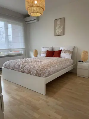 a bedroom with a large white bed with red pillows at Chez HN Confort et Style in Edegem