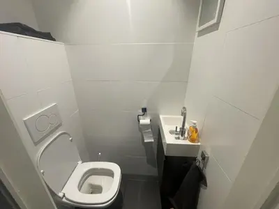 a small bathroom with a toilet and a sink at Chez HN Confort et Style in Edegem