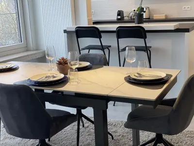 a table with chairs and wine glasses on it at Chez HN Confort et Style in Edegem