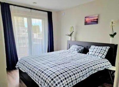 a bedroom with a bed with a plaid blanket and a window at Homeawayfromhomeghent with private parking in Ghent