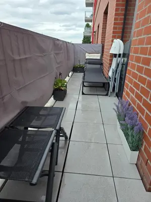 a patio with chairs and potted plants on a building at Homeawayfromhomeghent with private parking in Ghent