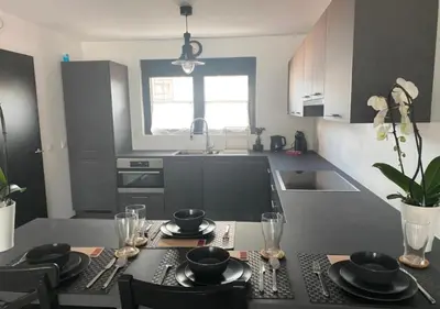 a kitchen with a table with plates and glasses on it at Homeawayfromhomeghent with private parking in Ghent