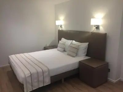 a bedroom with a large bed with two lamps on it at Shelter-rooms in Buysinghen