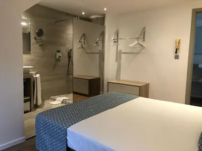 a bedroom with a white bed and a shower at Shelter-rooms in Buysinghen