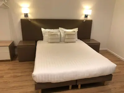 a bedroom with a large bed with white sheets and pillows at Shelter-rooms in Buysinghen