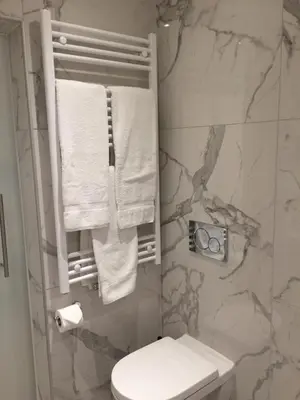 a bathroom with a toilet and towels on a wall at Shelter-rooms in Buysinghen