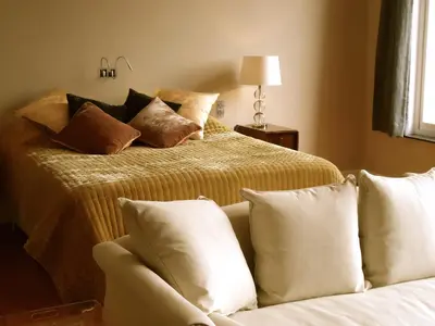 a bedroom with two beds and a couch with pillows at Maison Flagey Brussels in Brussels