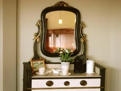 a mirror on top of a dresser with flowers on it at Maison Flagey Brussels in Brussels