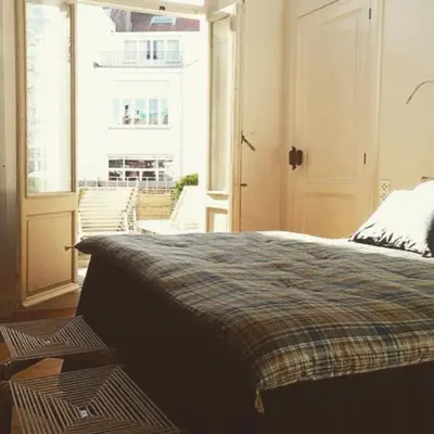 a bedroom with a bed and a large window at Maison Flagey Brussels in Brussels