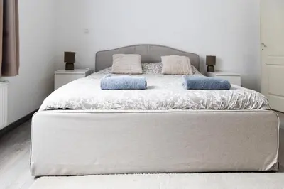 a bedroom with a large bed with two pillows on it at Appartement confortable avec garage premier étage sans terrasse in Brussels