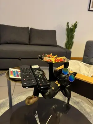 a table with a toy dog holding a remote control at Appartement de Luxe Entièrement Rénové - Proche Aéroport de Bruxelles, Quartier Chic in Brussels