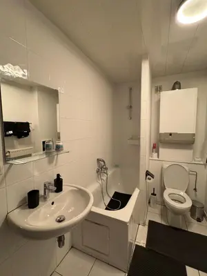 a white bathroom with a sink and a toilet at Appartement de Luxe Entièrement Rénové - Proche Aéroport de Bruxelles, Quartier Chic in Brussels