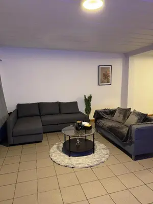 a living room with two couches and a coffee table at Appartement de Luxe Entièrement Rénové - Proche Aéroport de Bruxelles, Quartier Chic in Brussels