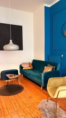 a living room with a blue couch and a table at Royal South II - Stylish apartment in Antwerp Zuid in Antwerp