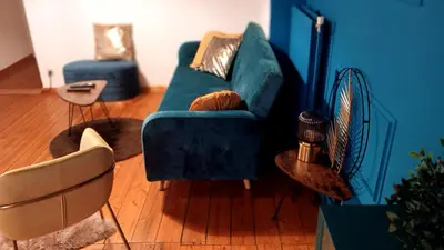 a living room with a blue couch and chairs at Royal South II - Stylish apartment in Antwerp Zuid in Antwerp