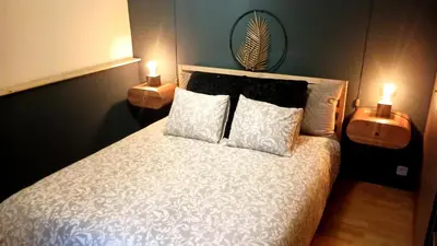 a bedroom with a white bed with two lit candles at Royal South II - Stylish apartment in Antwerp Zuid in Antwerp