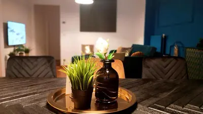 a bottle on a table with a potted plant on it at Royal South II - Stylish apartment in Antwerp Zuid in Antwerp