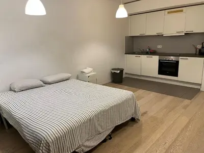 a bedroom with a bed and a kitchen at Brussels studio in Brussels