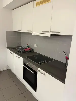 a kitchen with white cabinets and a black stove top oven at Brussels studio in Brussels