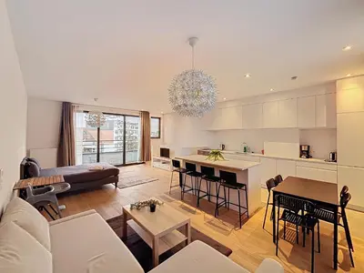 a living room with a couch and a table at Penthouse Cinquantenaire in Brussels
