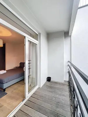 a bedroom with a bed and a balcony at Penthouse Cinquantenaire in Brussels