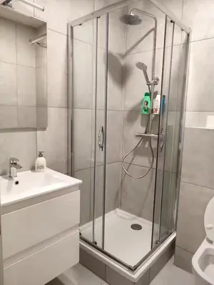 a shower with a glass door in a bathroom at City Center location 1BR Apartment near Station! in Antwerp