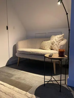 a bed with pillows and a table in a room at The Conservatory, a cosy private attic located central between Ghent Antwerp Brussels in Lokeren