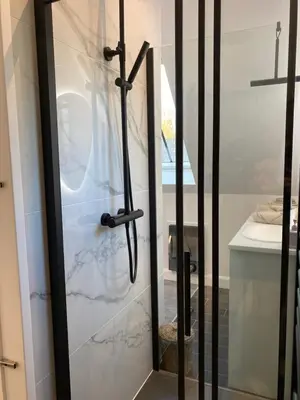 a bathroom with a shower with a glass door at The Conservatory, a cosy private attic located central between Ghent Antwerp Brussels in Lokeren
