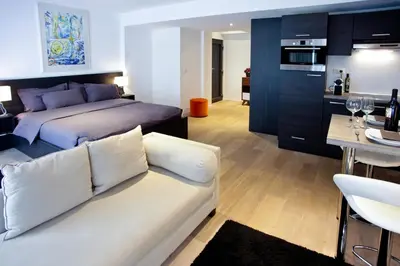 a living room with a bed and a white couch at Flat Moliere in Brussels