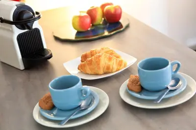 a table with two blue cups and bread and apples at Flat Moliere in Brussels