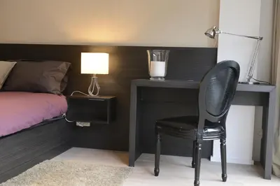 a bedroom with a desk and a chair next to a bed at Flat Moliere in Brussels