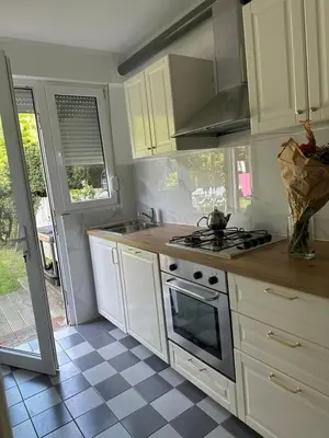 a kitchen with white cabinets and a stove top oven at Studio - simply living in Antwerp