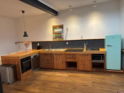 a kitchen with wooden cabinets and a blue refrigerator at Richard XIII in Antwerp